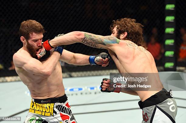 Michael Chiesa punches Mitch Clarke in their lightweight fight during the UFC Fight Night event at the Patriot Center on April 4, 2015 in Fairfax,...