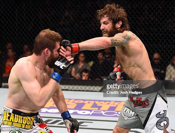 Michael Chiesa punches Mitch Clarke in their lightweight fight during the UFC Fight Night event at the Patriot Center on April 4, 2015 in Fairfax,...