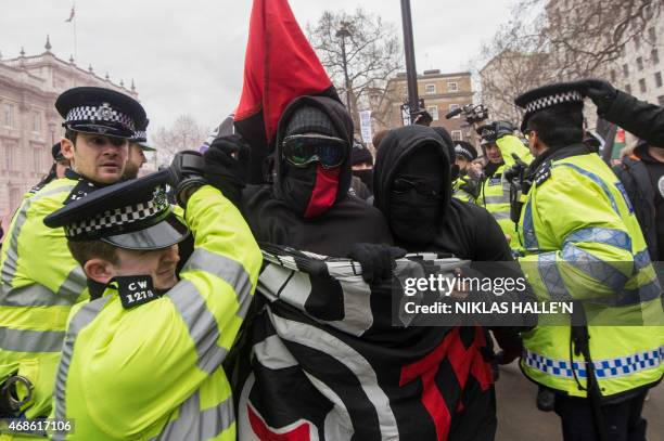 Police officers scuffle with South London Anti-Fascists activists on Whitehall during a counter protest against a rally by the British off-shoot of...