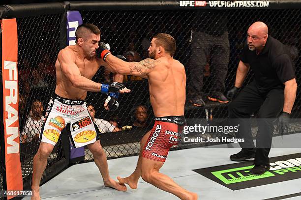 Chad Mendes punches Ricardo Lamas in their featherweight fight during the UFC Fight Night event at the Patriot Center on April 4, 2015 in Fairfax,...