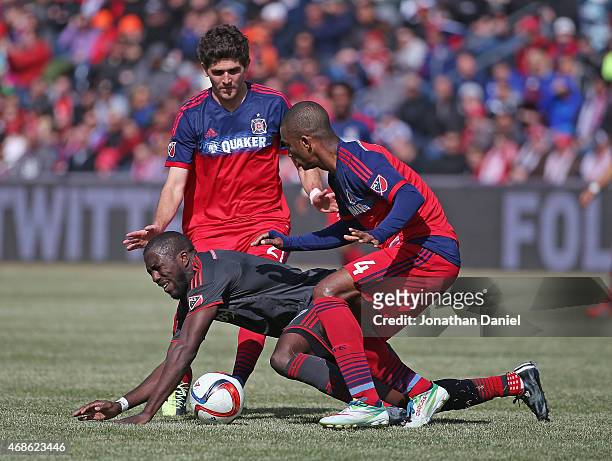 Jozy Altidore of Toronto FC hits the ground under pressure from Adailton and Chris Ritter of Chicago Fire during an MLS match at Toyota Park on April...