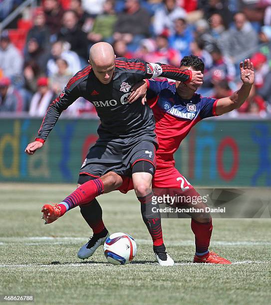 Michael Bradley of Toronto FC gets his hand in the face of Quincy Amarikwa of Chicago Fire as the battle for the ball during an MLS match at Toyota...