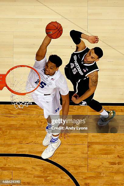 Jahlil Okafor of the Duke Blue Devils goes up for a dunk against Denzel Valentine of the Michigan State Spartans in the second half during the NCAA...