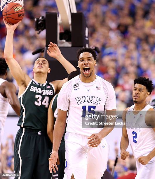 Jahlil Okafor of the Duke Blue Devils reacts after a play in the second half as Gavin Schilling of the Michigan State Spartans looks on during the...