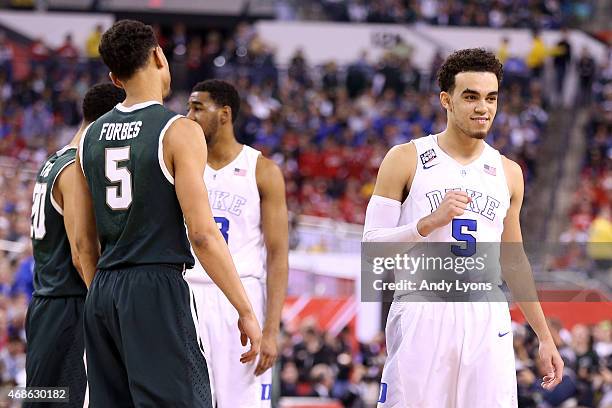 Tyus Jones of the Duke Blue Devils reacts after defeating the Michigan State Spartans as Bryn Forbes looks on during the NCAA Men's Final Four...