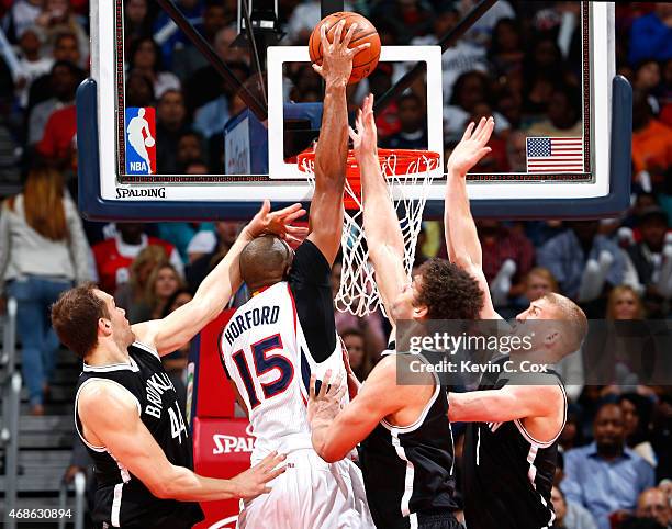 Al Horford of the Atlanta Hawks dunks against Bojan Bogdanovic, Brook Lopez, and Mason Plumlee of the Brooklyn Nets at Philips Arena on April 4, 2015...