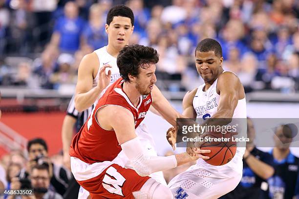 Frank Kaminsky of the Wisconsin Badgers handles the ball against Devin Booker and Aaron Harrison of the Kentucky Wildcats in the first half during...