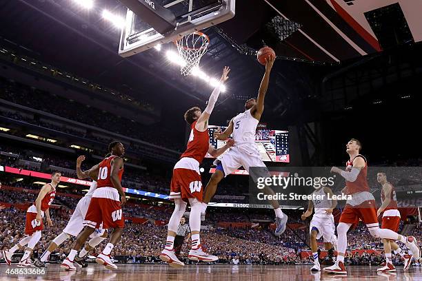 Andrew Harrison of the Kentucky Wildcats drives to the basket against Frank Kaminsky of the Wisconsin Badgers in the first half during the NCAA Men's...