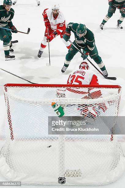 Zach Parise of the Minnesota Wild scores a goal with Kyle Quincey and goalie Jimmy Howard of the Detroit Red Wings defending during the game on April...