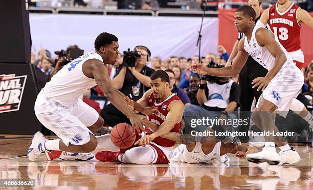 Kentucky's Dakari Johnson and Tyler Ulis battle for a loose ball against Wisconsin's Traevon Jackson during the first half in the NCAA Tournament...