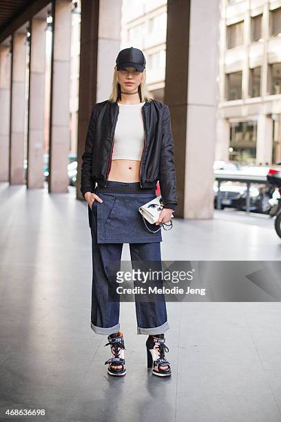 Model Soo Joo Park exits the Fay show in an Acne hat, Aritzia top, Kara Ross bag, and Fay jeans and shoes on Day 1 of Milan Fashion Week FW15 on...
