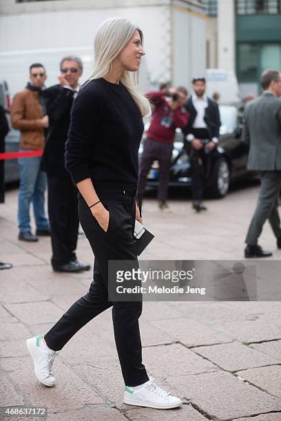 Sarah Harris of Vogue UK enters Ferragamo in a Balmain jumper, Gucci trousers, and Adidas Stan Smith sneakers on Day 5 of Milan Fashion Week FW15 on...