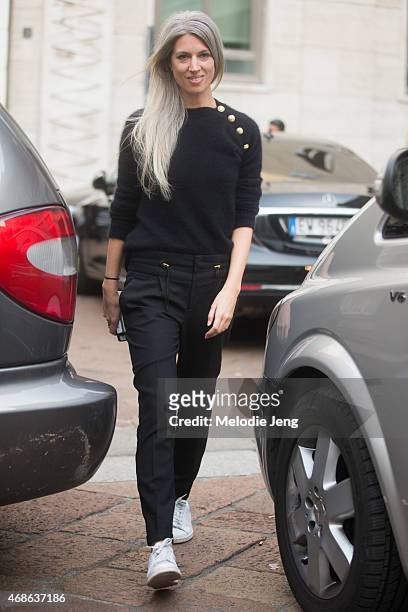 Sarah Harris of Vogue UK enters Ferragamo in a Balmain jumper, Gucci trousers, and Adidas Stan Smith sneakers on Day 5 of Milan Fashion Week FW15 on...