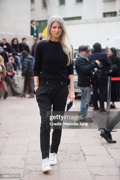 Sarah Harris of Vogue UK enters Ferragamo in a Balmain jumper, Gucci trousers, and Adidas Stan Smith sneakers on Day 5 of Milan Fashion Week FW15 on...