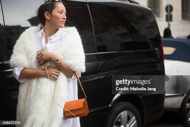 Tina Leugn wears REV BY REN sunglasses, Bulgari jewelry, a Moschino fur coat, Vivetta shirt, and Marni bag on Day 5 of Milan Fashion Week FW15 on...