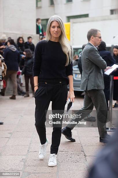 Sarah Harris of Vogue UK enters Ferragamo in a Balmain jumper, Gucci trousers, and Adidas Stan Smith sneakers on Day 5 of Milan Fashion Week FW15 on...