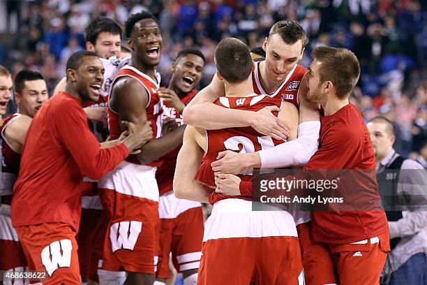 Josh Gasser and Sam Dekker of the Wisconsin Badgers celebrate with teammates after defeating the Kentucky Wildcats during the NCAA Men's Final Four...