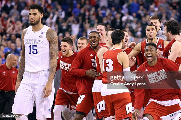 The Wisconsin Badgers celebrate after defeating the Kentucky Wildcats as Willie Cauley-Stein looks on during the NCAA Men's Final Four Semifinal at...