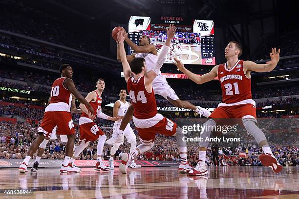 Aaron Harrison of the Kentucky Wildcats drives to the basket against Frank Kaminsky of the Wisconsin Badgers and is fouled in the second half during...