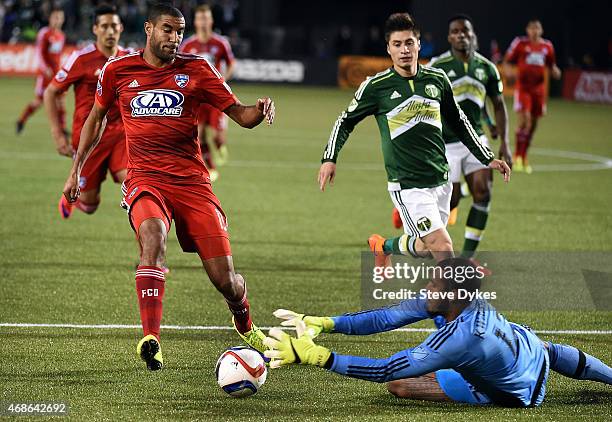 Adam Kwarasey of Portland Timbers dives to stop the ball as Tesho Akindele of FC Dallas closes in during the first half of the game at Providence...