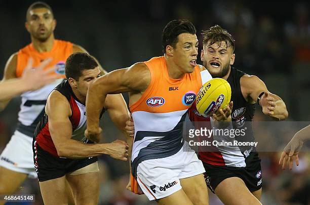 Dylan Shiel of the Giants breaks free from a tackle by Leigh Montagna and Marverick Weller of the Saints during the round one AFL match between the...