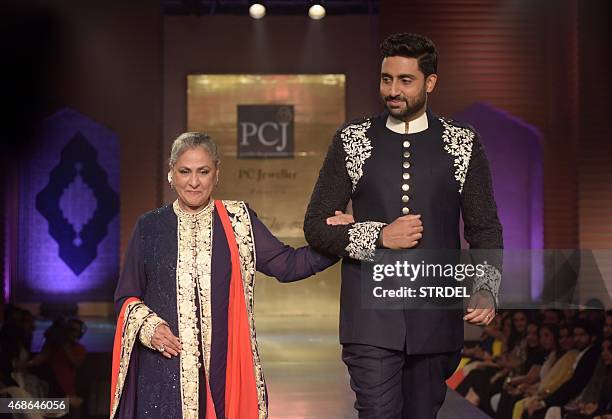 Indian Bollywood actors Jaya Bachchan and her son Abhishek Bachchan model creations by designer Manish Malhotra during a charity fashion show in...