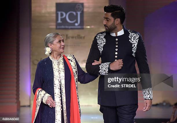 Indian Bollywood actors Jaya Bachchan and her son Abhishek Bachchan model creations by designer Manish Malhotra during a charity fashion show in...