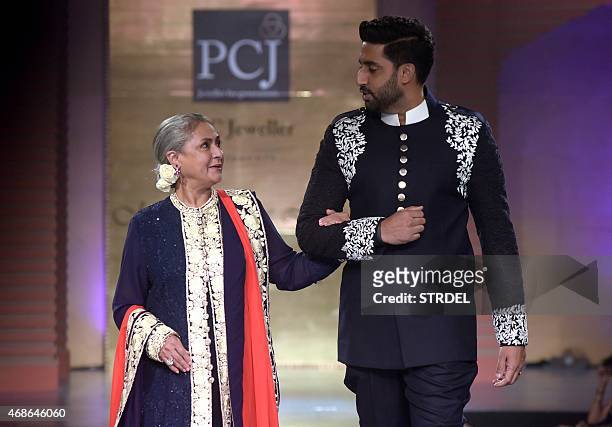 Indian Bollywood actors Jaya Bachchan and her son Abhishek Bachchan model creations by designer Manish Malhotra during a charity fashion show in...
