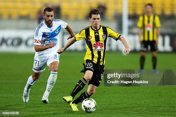 Michael McGlinchey of the Phoenix beats the defence of Carl Valeri of the Victory during the round 24 A-League match between the Wellington Phoenix...