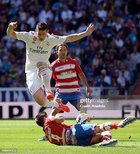 Real Madrid's James Rodriguez vies with Granada's Fran Rico during the Spanish La Liga football match between Real Madrid CF vs Granada CF at the...