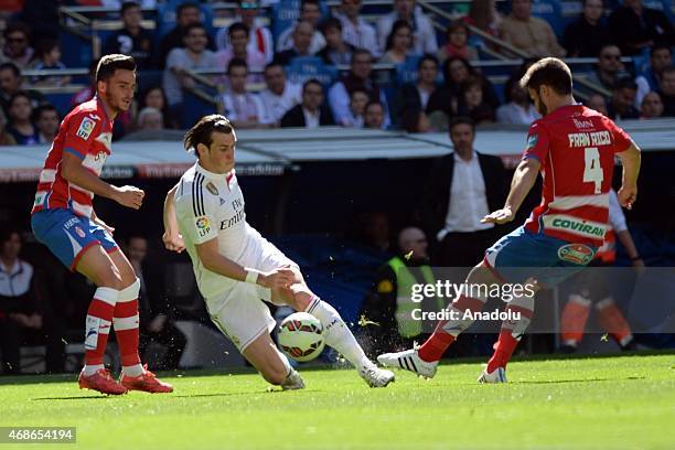 Real Madrid's Gareth Bale vies with Granada's Fran Rico during the Spanish La Liga football match between Real Madrid CF vs Granada CF at the...