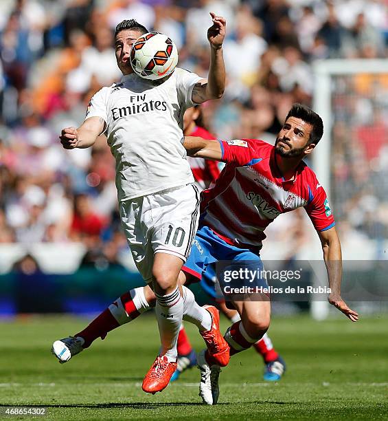James Rodriguez of Real Madrid and Fran Rico of Granada cf compete for the ball during the La Liga match between Real Madrid CF and Granda CF at...