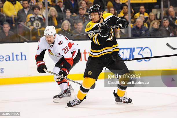 Jarome Iginla of the Boston Bruins against Matt Kassian of the Ottawa Senators at the TD Garden on February 8, 2014 in Boston, Massachusetts.