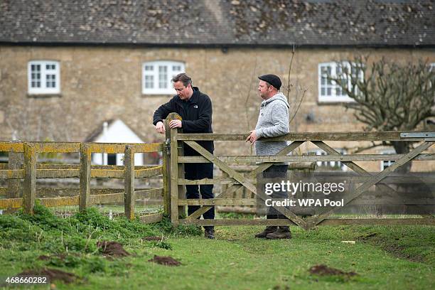 Prime Minister and leader of the Conservative Party David Cameron meets with farmer Julian Tustian at Dean Lane farm near the village of Chadlington...