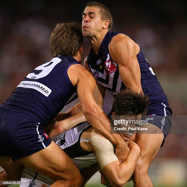 Angus Monfries of the Power gets tackled by Matt de Boer of the Dockers and Stephen Hill of the Dockers during the round one AFL match between the...