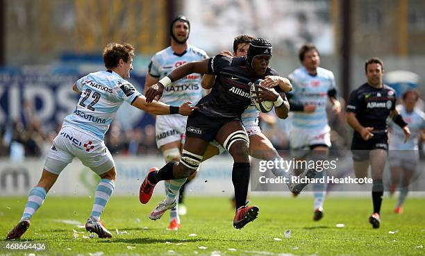 Maro Itoje of Saracens is tackled by Johannes Goosen and Brice Dulin of Metro during the European Rugby Champions Cup Quater Final between Racing...