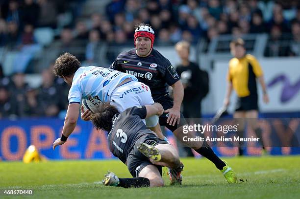 Johannes Goosen of Racing Metro 92 is tackled by Marcelo Bosch and Schalk Brits of Saracens during the European Rugby Champions Cup quarter final...