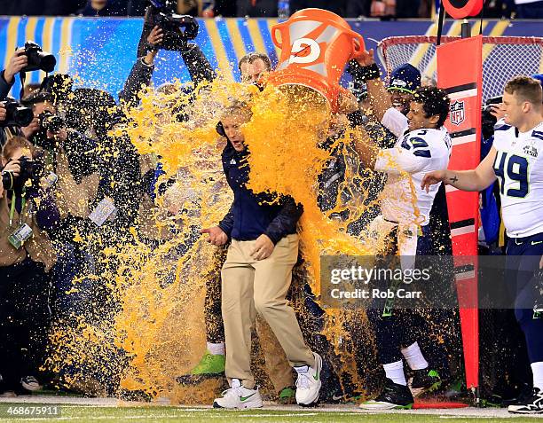 Tight end Zach Miller and quarterback Russell Wilson of the Seattle Seahawks dump Gatorade on head coach Pete Carroll in the fourth quarter of Super...