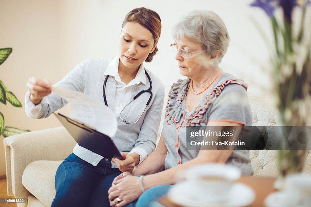 Joven doctora es consultar a un paciente senior