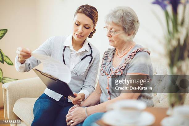 young female doctor is consulting a senior patient - explaining stock pictures, royalty-free photos & images
