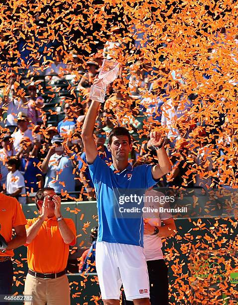 Novak Djokovic of Serbia holds aloft the Butch Bucholz trophy after his three set victory against Andy Murray of Great Britain in the mens final...