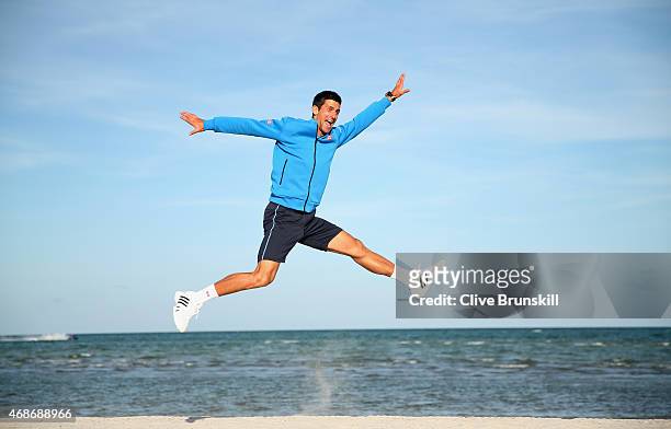 Novak Djokovic of Serbia leaps in the air on Crandon Park beach after his three set victory against Andy Murray of Great Britain in the mens final...