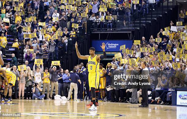 Paul George of the Indiana Pacers waves to the crowd as he walks onto the court for the first time in the game against the Miami Heat at Bankers Life...