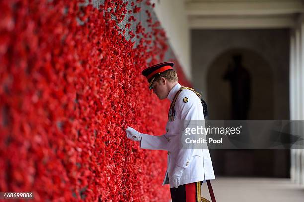 Prince Harry places a poppy at the Roll of Honour during a visit to the Australian War Memorial on April 6, 2015 in Canberra, Australia. Prince...