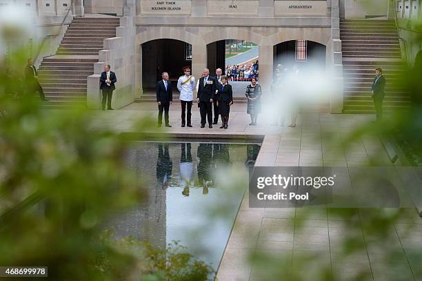 Prince Harry speaks to officials as he stands at the pool of Remembrance during a visit to the Australian War Memorial on April 6, 2015 in Canberra,...