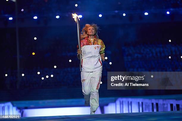 Winter Olympics: Russia Olympic tennis medalist and torchbearer Maria Sharapova running with Olympic flame at Fisht Olympic Stadium. Sochi, Russia...