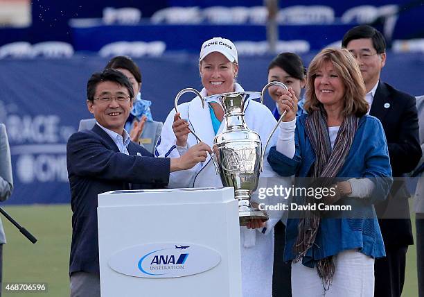 Brittany Lincicome of the USA is presented with the ANA Inspiration Dinah Shore Trophy by Mr Shinya Katanozaka the President and CEO of ANA Holdings...