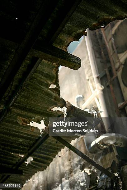 broken crimp plate roof in alley - broken air conditioner stock pictures, royalty-free photos & images