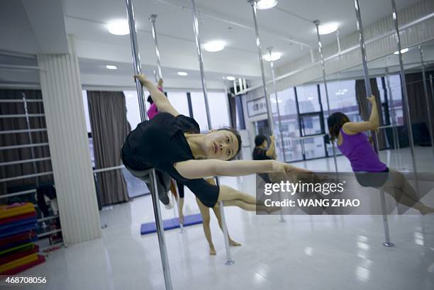 This picture taken on April 2, 2015 shows a group of Chinese women attending a pole dancing lesson in Tianjin. AFP PHOTO /WANG ZHAO