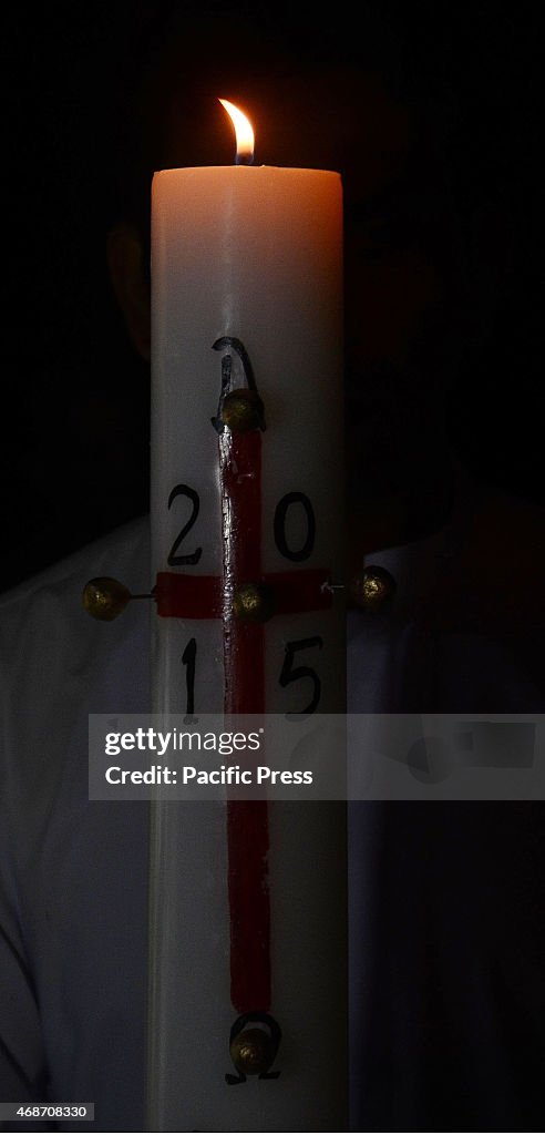 Pakistani Christian worshipers pray and hold candles during...